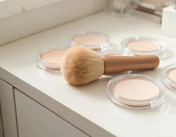 makeup brush for pressed powder on a cosmetics bench, illustration only